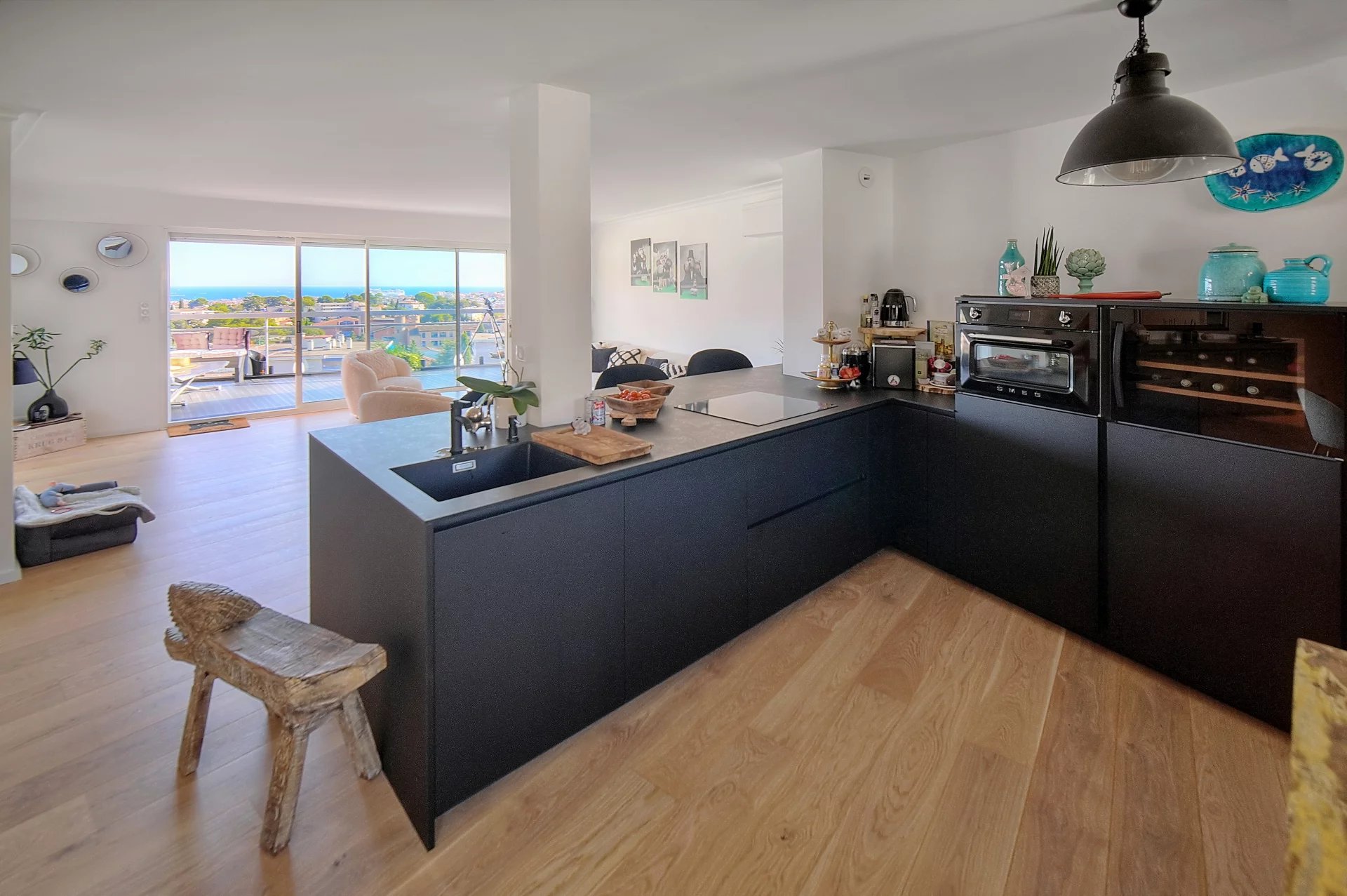Interior of a modern apartment with open kitchen and sea view.