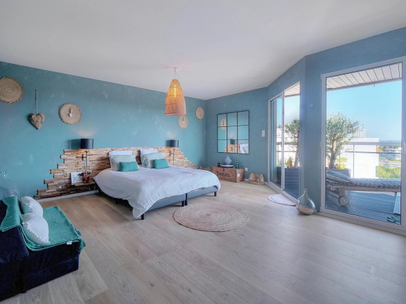 Room in a renovated apartment with sea view, turquoise walls and modern decor.