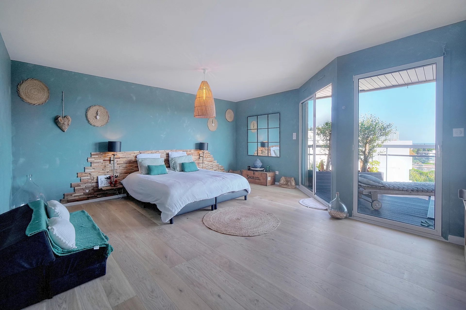 Room in a renovated apartment with sea view, turquoise walls and modern decor.