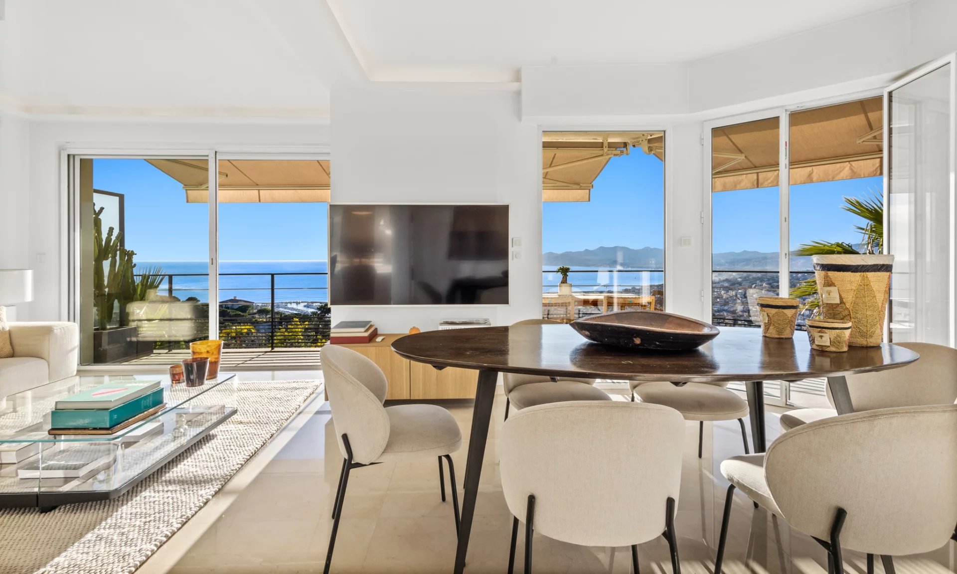 Appartement moderne avec vue mer à Cannes Intérieur d'un appartement moderne avec vue sur la mer, table à manger et salon lumineux.