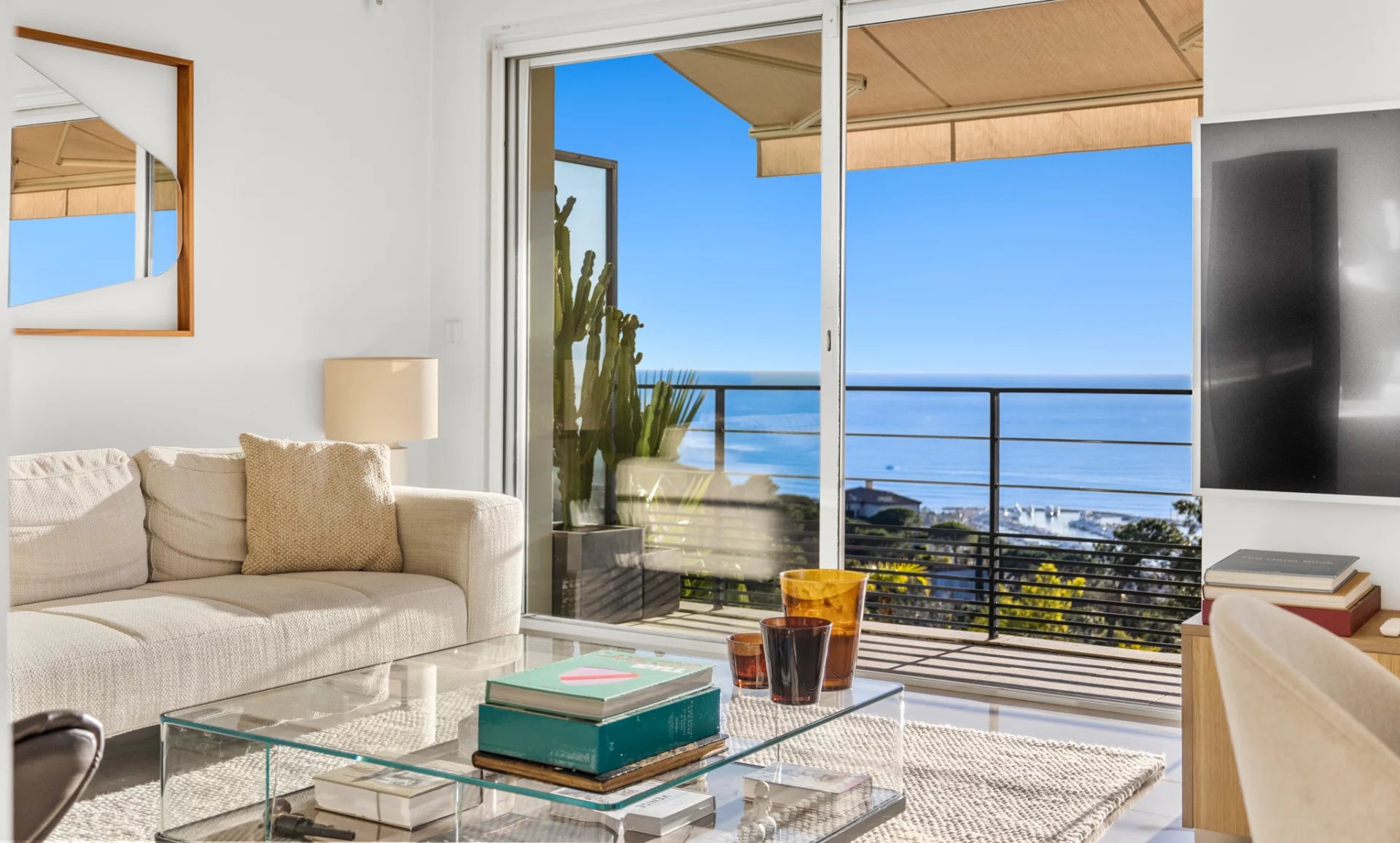 Appartement moderne avec vue panoramique Intérieur d'un appartement moderne avec vue sur la mer, salon lumineux et mobilier contemporain.