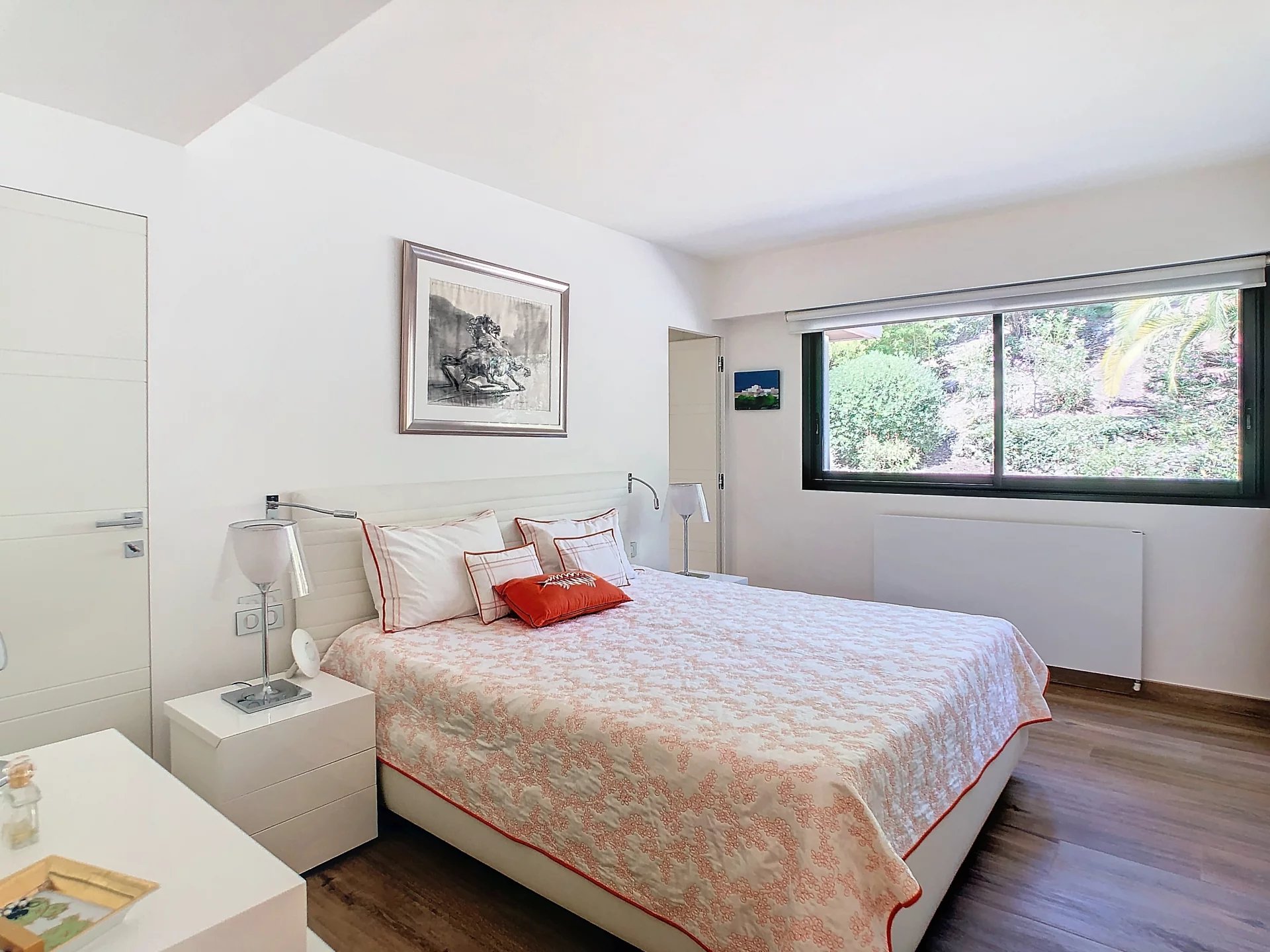 Chambre d'un appartement rénové avec lit double et fenêtres sur l'extérieur.