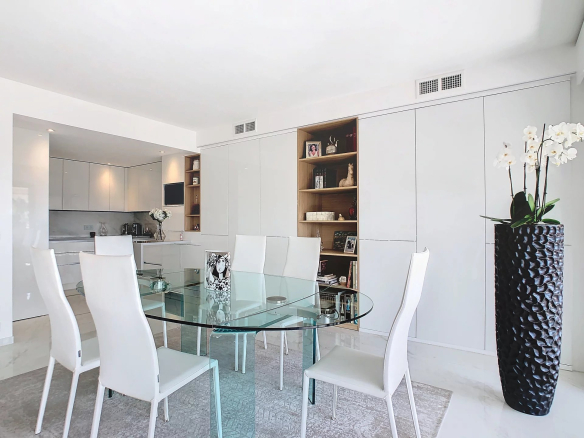 Intérieur d'un appartement rénové avec une salle à manger moderne et une cuisine ouverte.