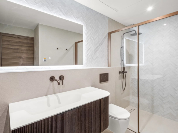 Salle de bain moderne avec douche à l'italienne et lavabo dans un appartement rénové.