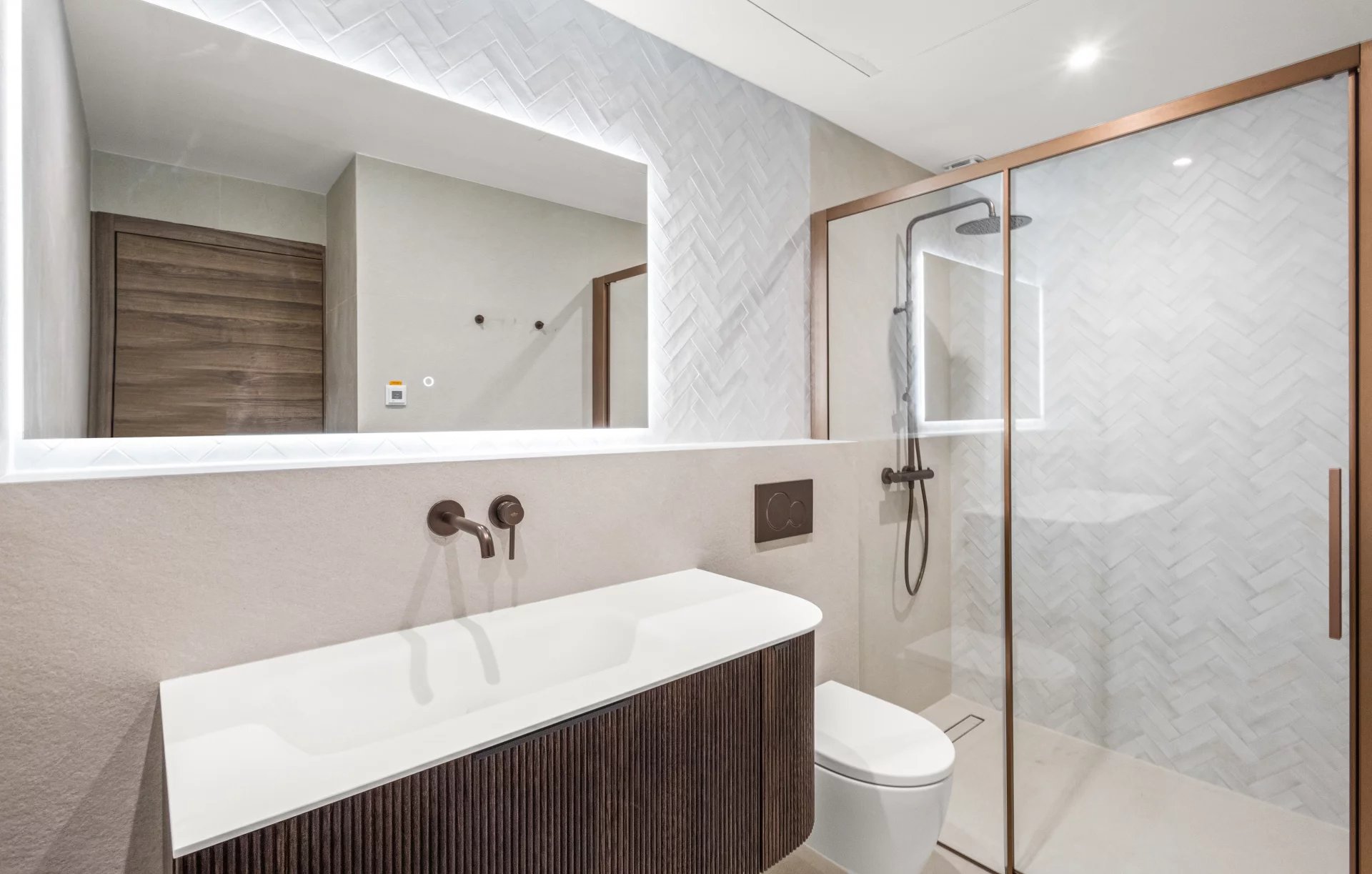 Salle de bain moderne avec douche à l'italienne et lavabo dans un appartement rénové.