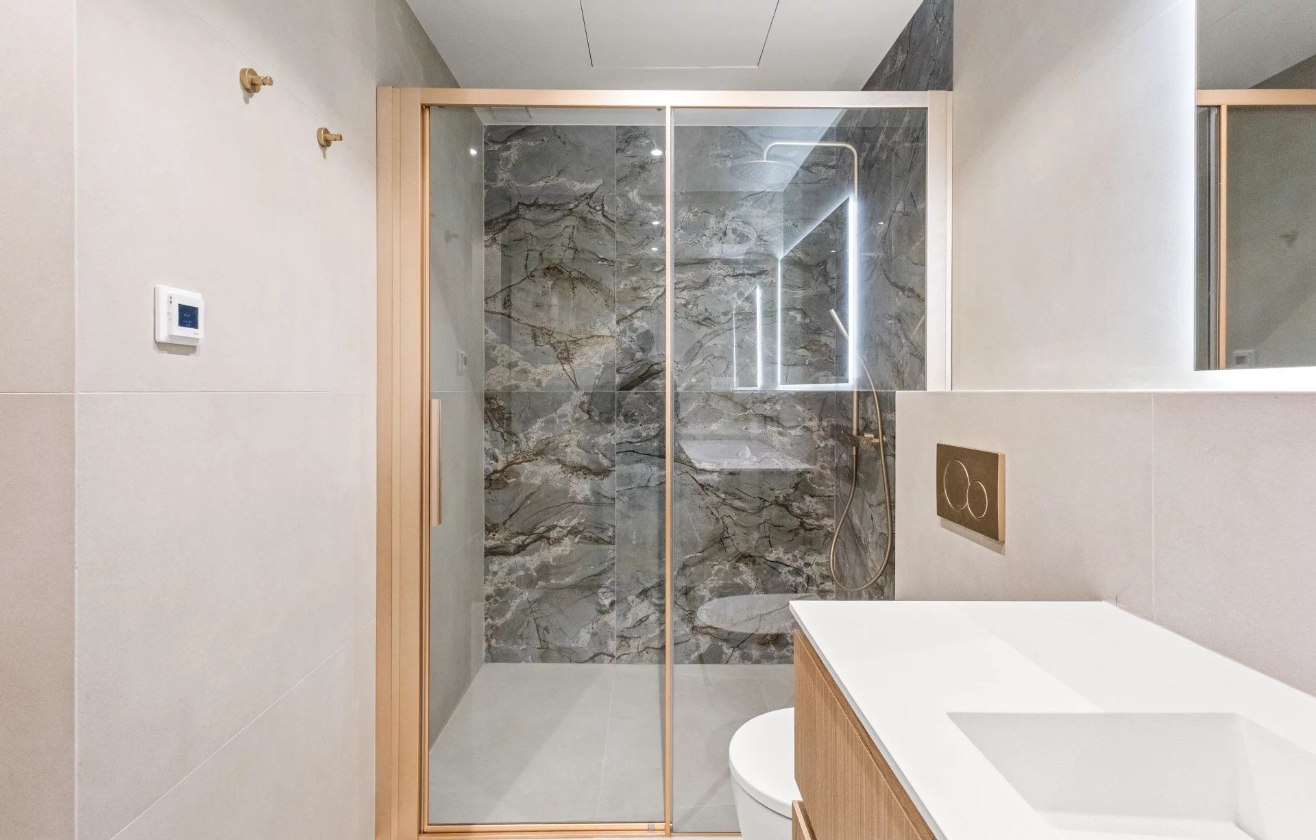 Salle de bain moderne avec douche en verre et murs en marbre