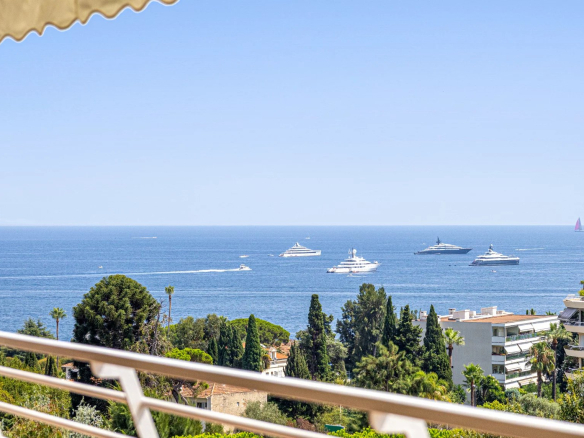Vue panoramique sur la mer depuis un balcon d'appartement à Cannes, avec des yachts au large.
