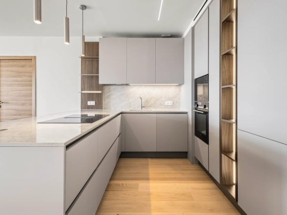 Cuisine moderne et rénovée d'un appartement à Cannes avec des meubles en bois et des appareils intégrés.