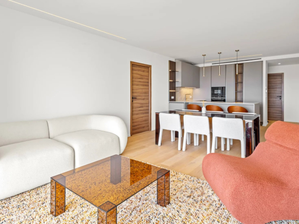 Intérieur d'un appartement rénové avec salon moderne, table à manger et cuisine ouverte.