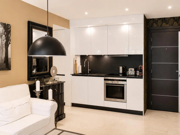 Modern and elegant kitchen in an apartment in Cannes, with an adjacent living room.