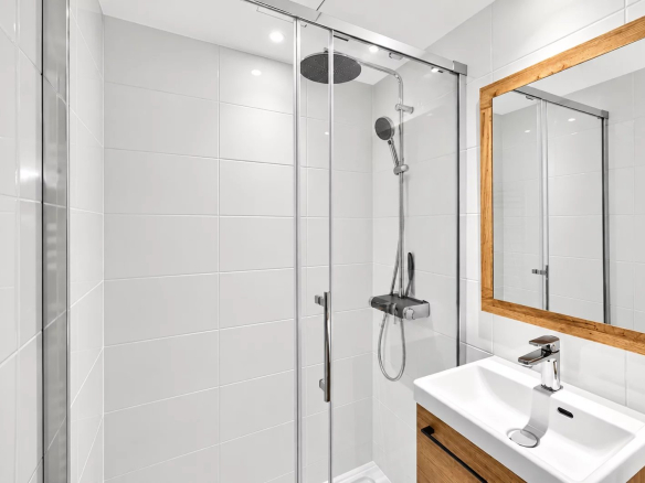 Modern bathroom with walk-in shower and wooden vanity unit.