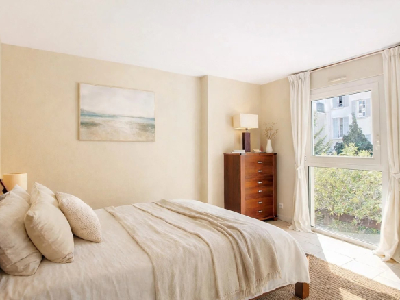Chambre d'une maison de ville à Cannes, avec fenêtre donnant sur un jardin.