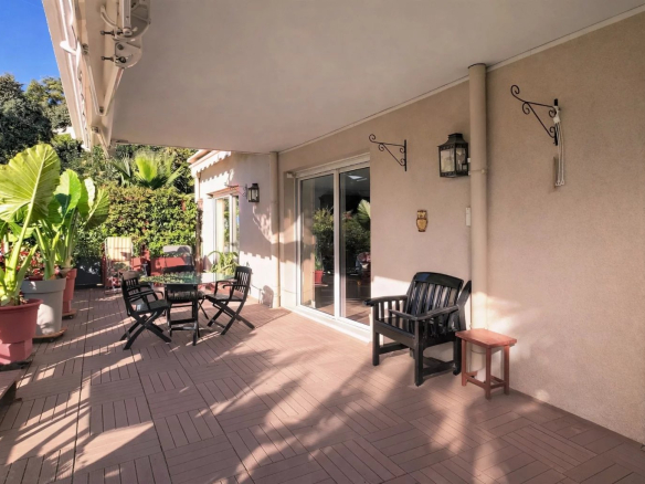 Terrasse d'un appartement à Cannes avec chaises et plantes.