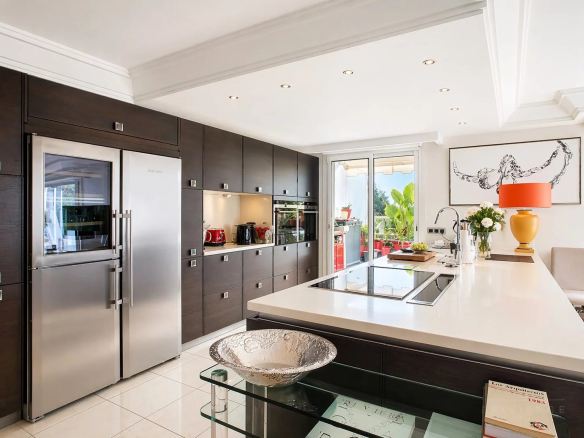 Cuisine moderne et équipée d'un appartement à Cannes avec îlot central et électroménagers en inox.