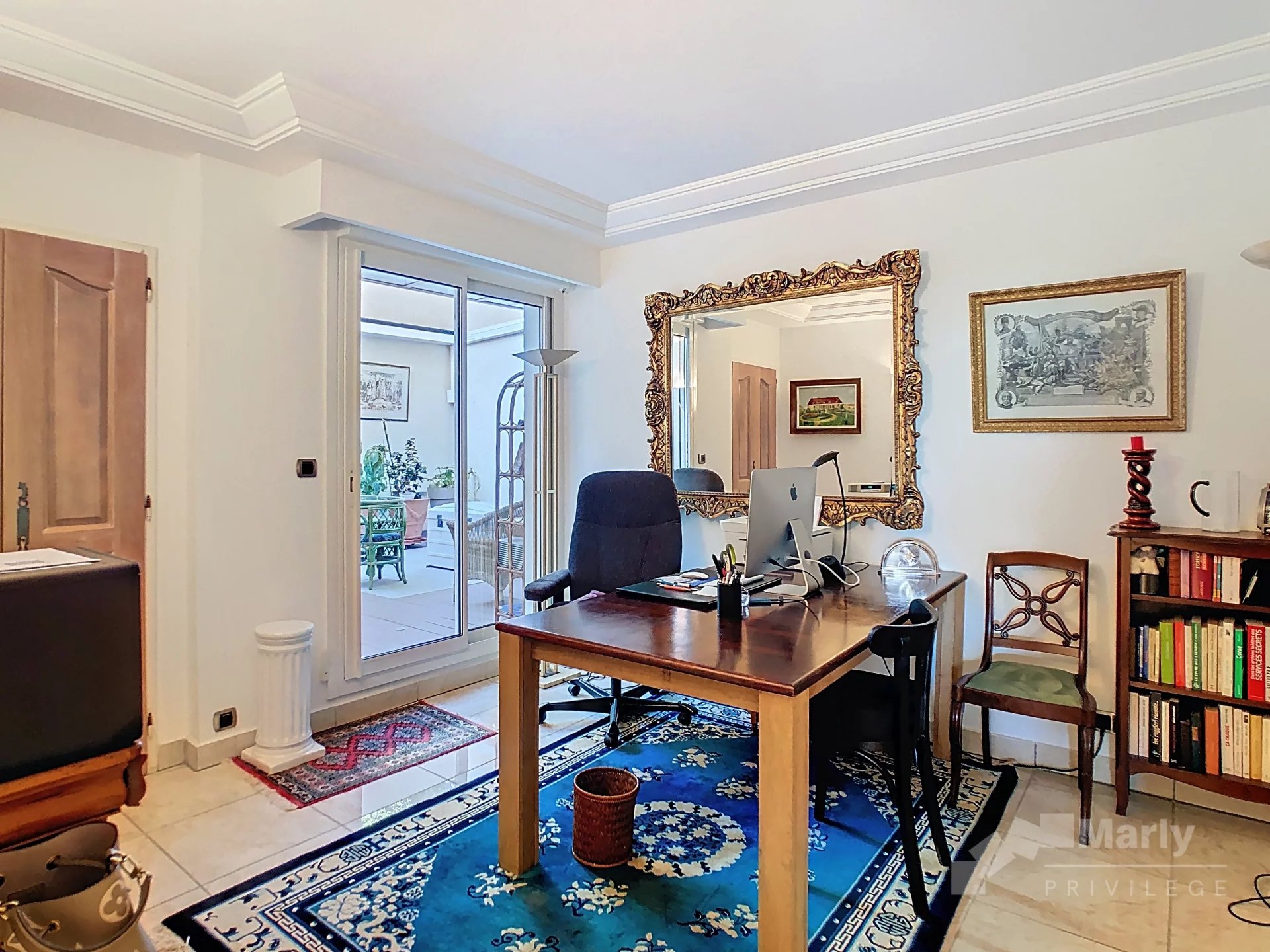 Bureau d’un appartement à Cannes Bureau dans un appartement lumineux avec un miroir doré et un accès à une terrasse.