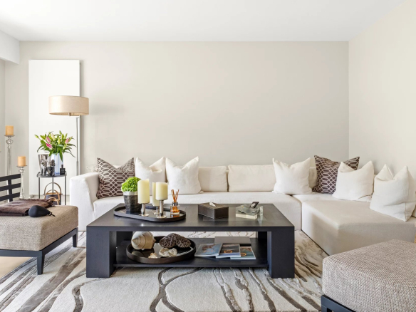 Living room of a renovated apartment, with white sofa, coffee table and modern decor.