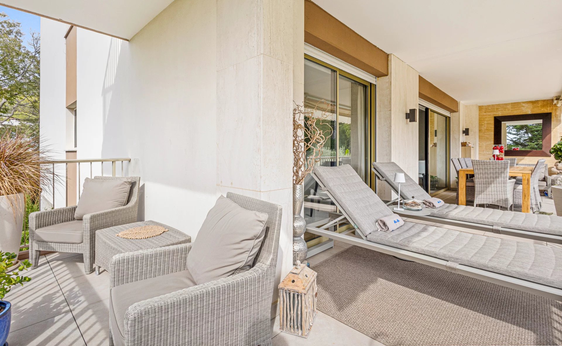 Terrace of a renovated apartment in Cannes Terrace of an apartment in Cannes with sun loungers and table, unobstructed view of a park.