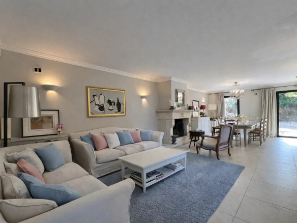 Interior of a villa with a bright living room, sofa, dining table and fireplace.