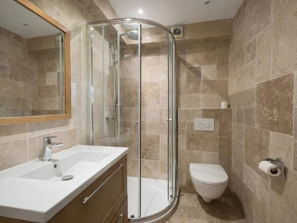 Modern bathroom with shower, sink and toilet.