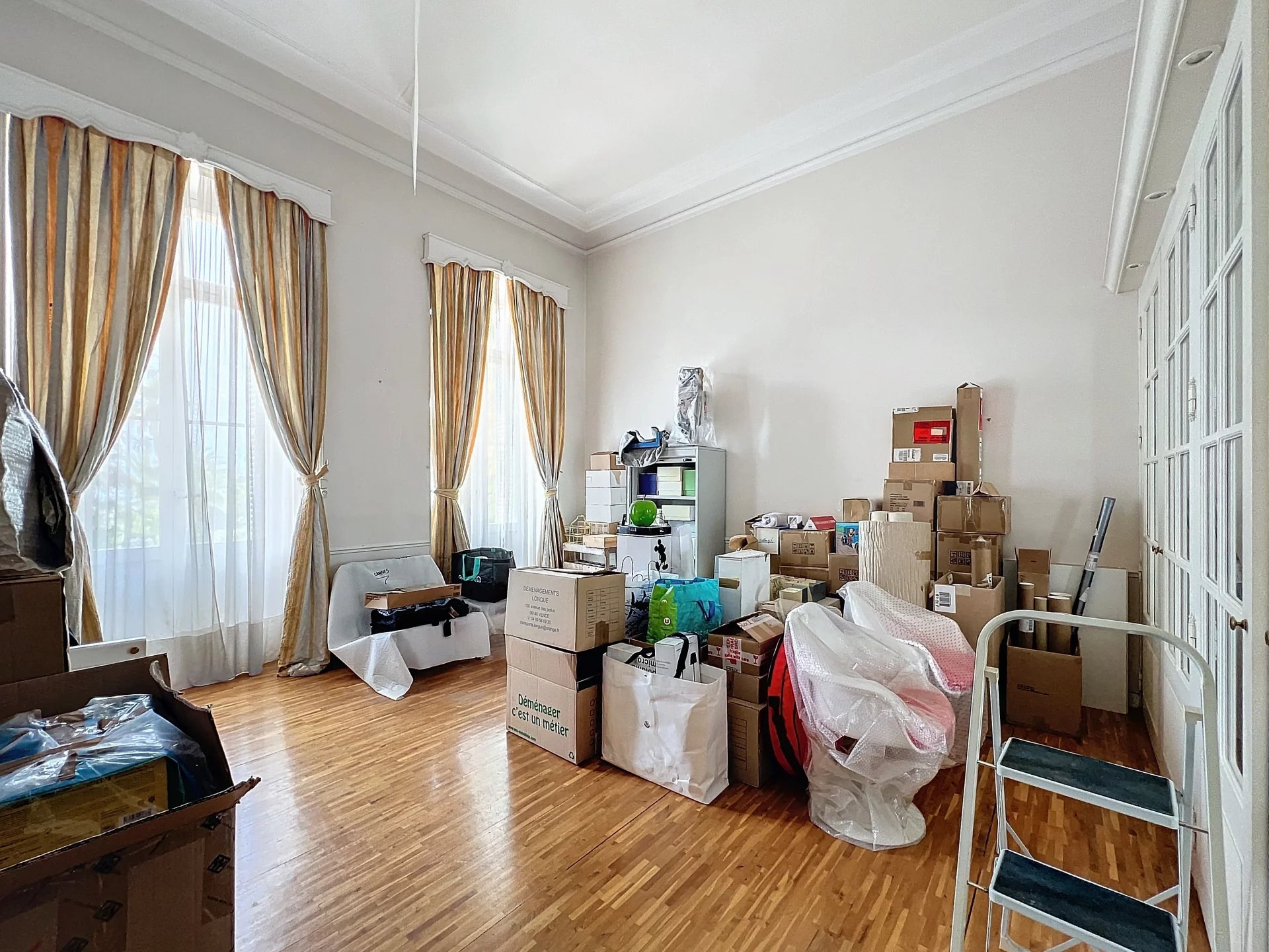 Appartement à rénover à Cannes Intérieur d'un appartement à Cannes avec des cartons et du mobilier, lumière naturelle