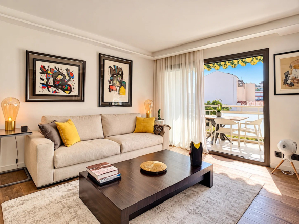 Salon d'un appartement contemporain avec canapé beige et table basse, accès à une terrasse.