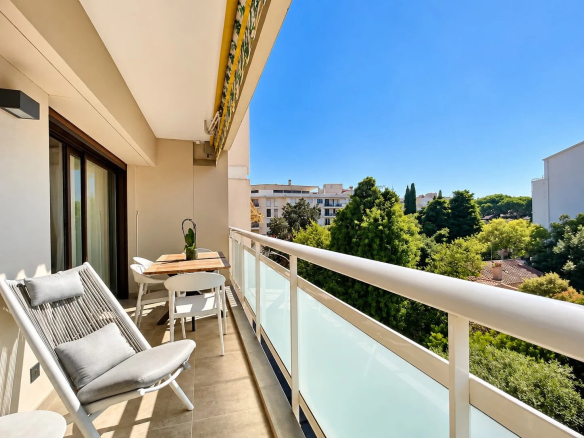 Terrasse d'un appartement contemporain à Cannes avec vue sur des arbres.