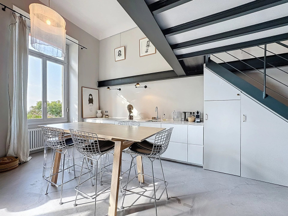 Intérieur d'un appartement type loft avec cuisine ouverte et salle à manger, style industriel.