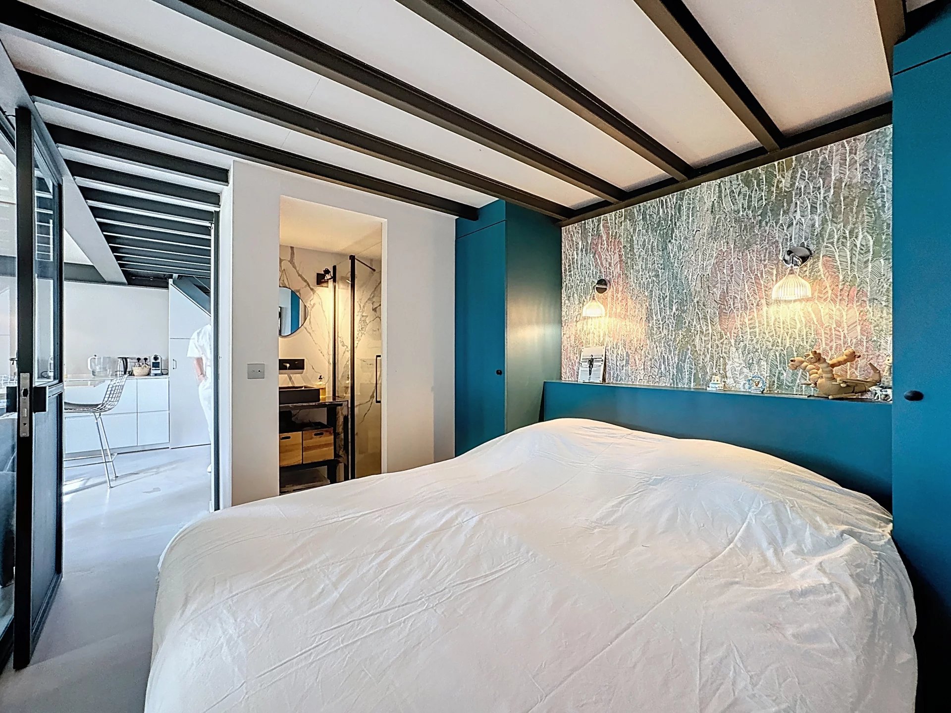 Chambre d’un loft à Cannes Chambre d'un appartement type loft à Cannes avec décoration moderne et mur coloré.
