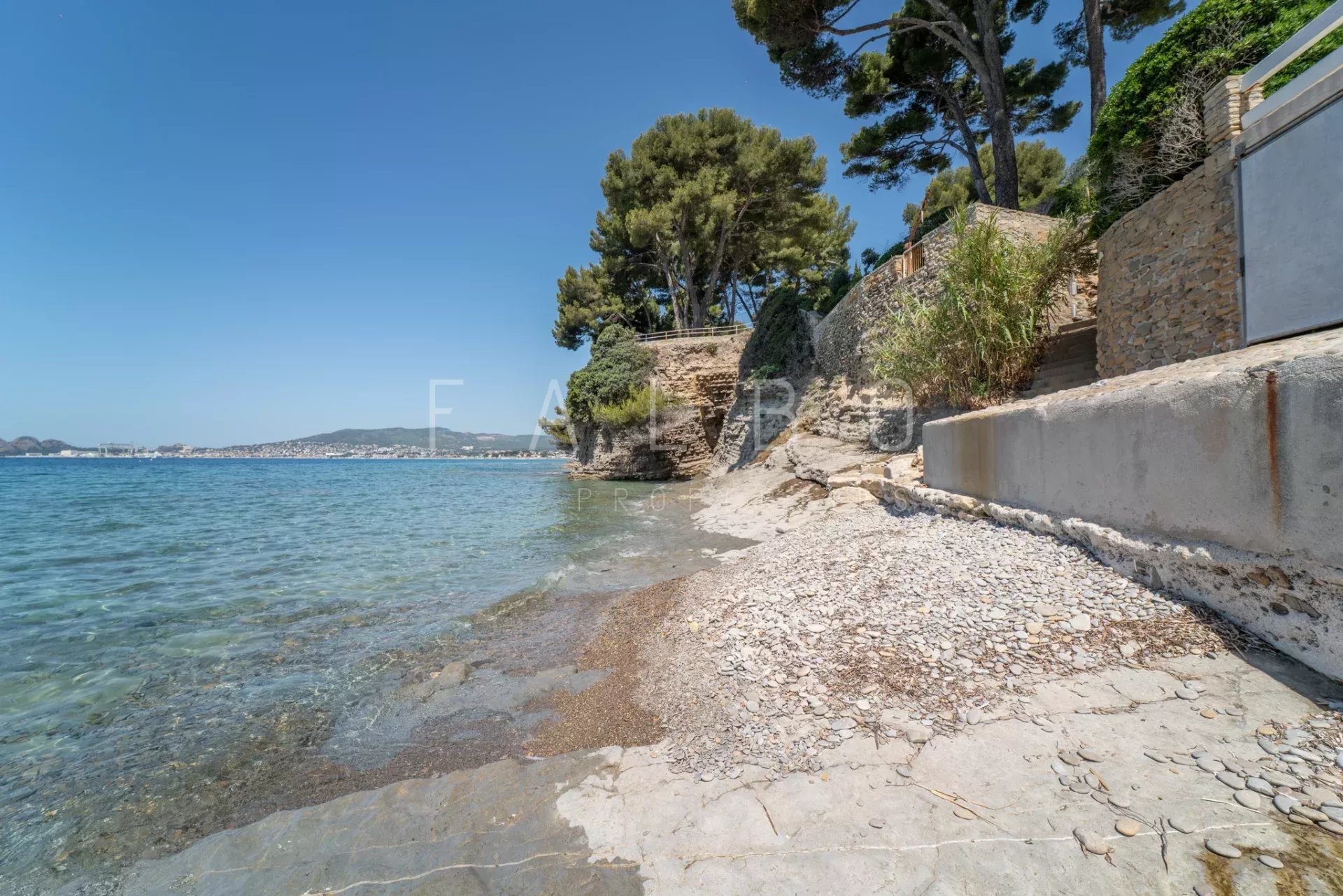 Pebble beach in La Ciotat, seaside with trees in the background.