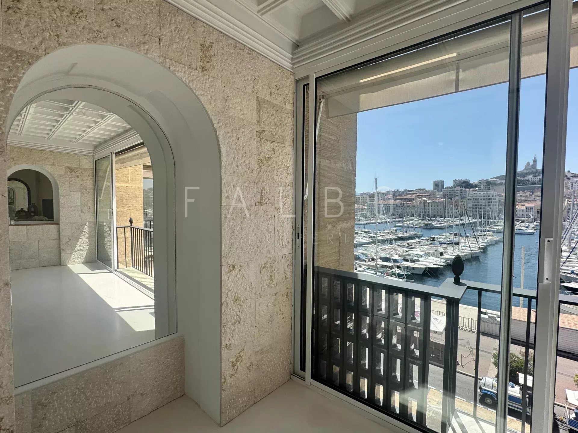 Interior of a renovated apartment with a view of the Old Port of Marseille.