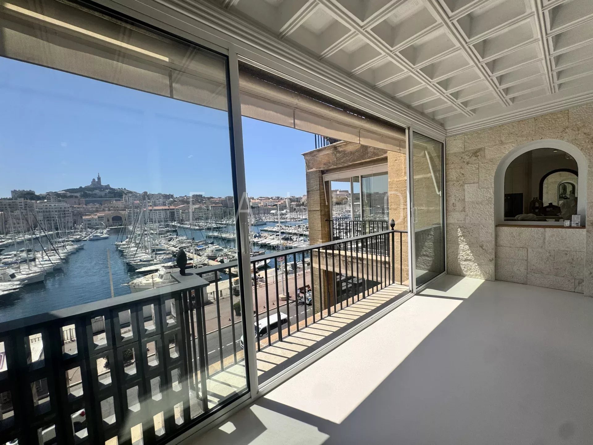 View from a renovated apartment with a balustrade overlooking the Old Port of Marseille.