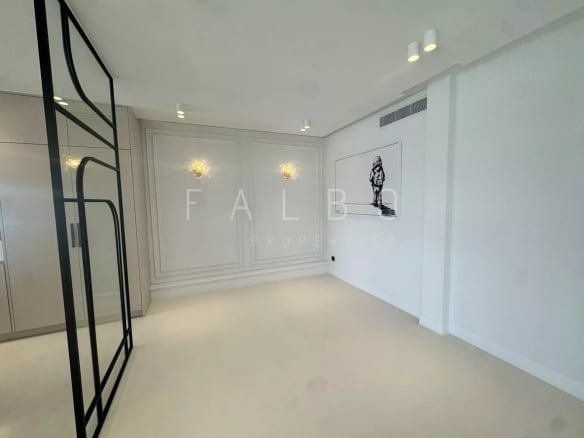 Interior of a renovated apartment with light walls and beige floor, modern lighting.