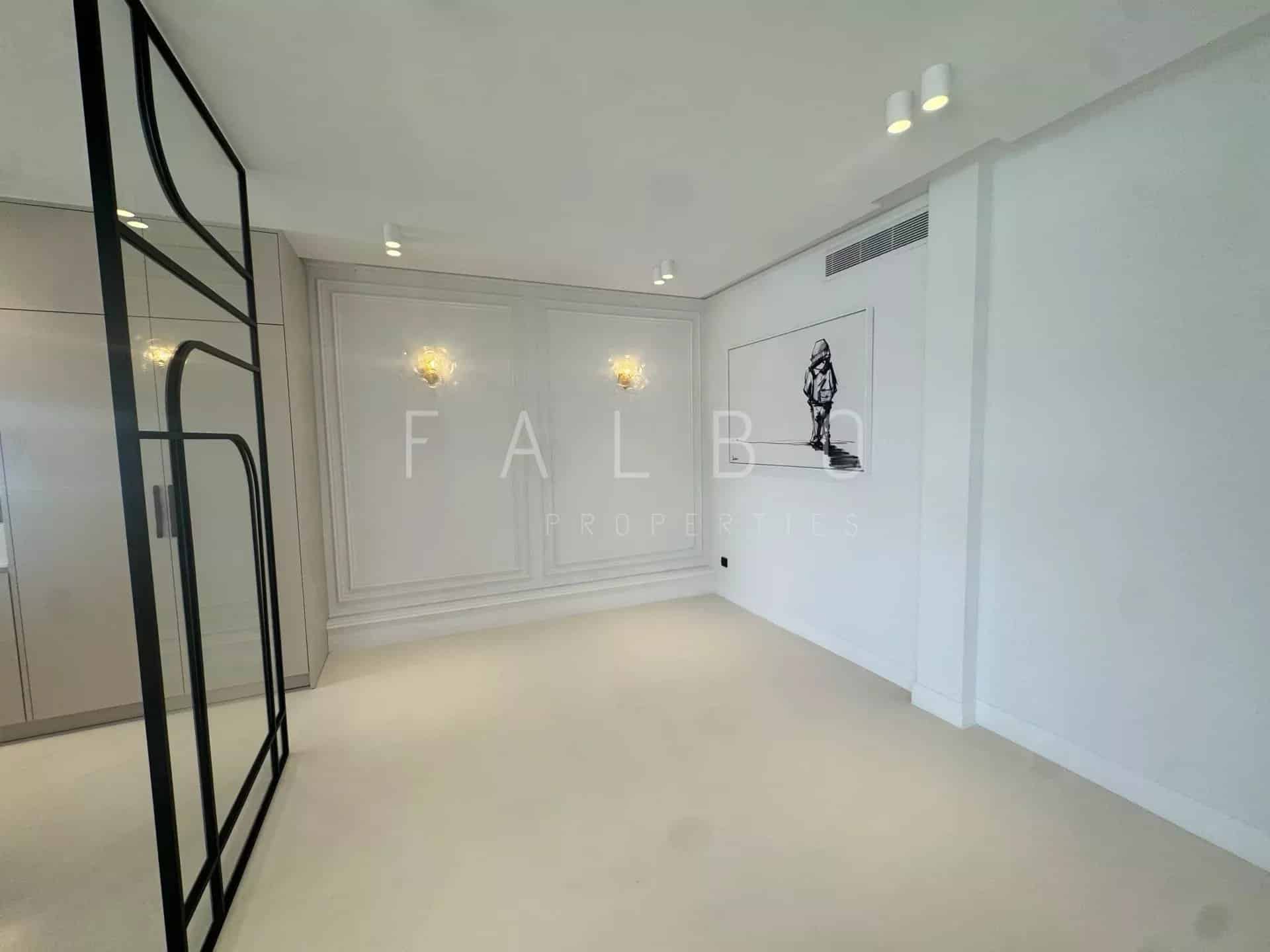 Interior of a renovated apartment with light walls and beige floor, modern lighting.