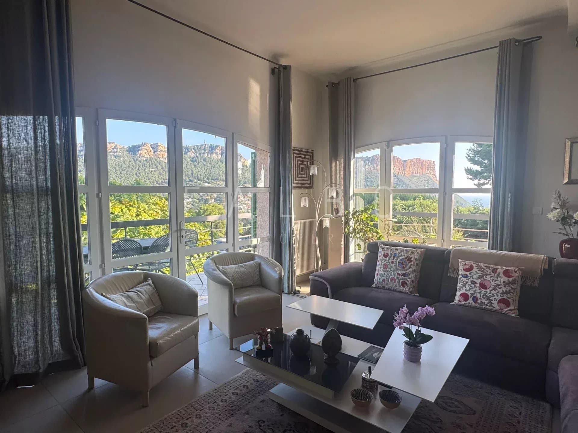 Intérieur d'une villa avec vue sur la mer et les collines de Cassis, salon lumineux et confortable.