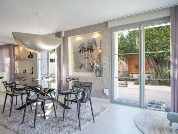 Intérieur d'une villa contemporaine avec salle à manger moderne et accès au jardin.