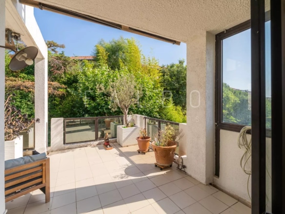Terrasse d'un appartement de standing à Marseille 8e, avec vue sur la verdure.