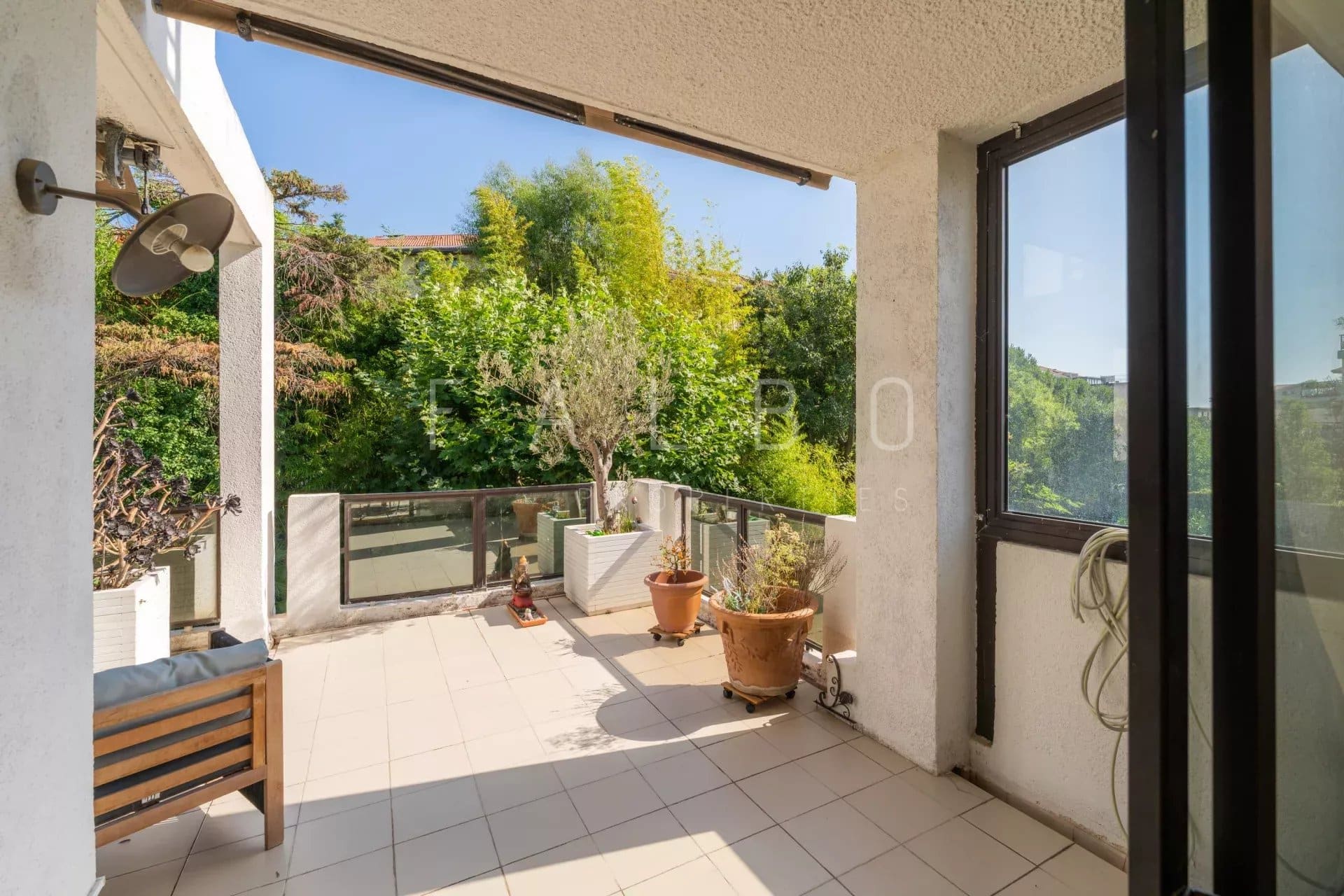 Terrasse d'un appartement de standing à Marseille 8e, avec vue sur la verdure.