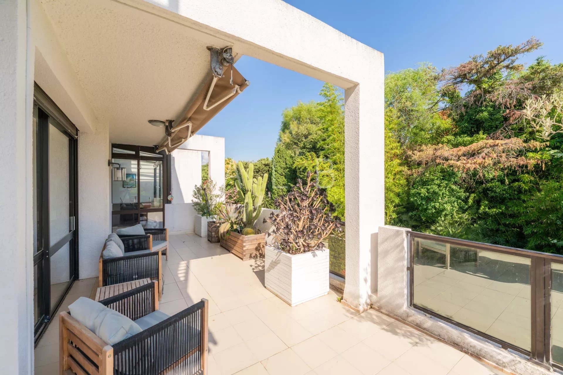 Terrasse d'un appartement en dernier étage avec mobilier extérieur et vue sur la verdure à Marseille 8e.
