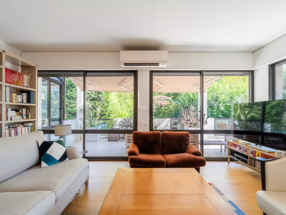 Intérieur d'un appartement moderne avec un salon lumineux et accès à une terrasse.