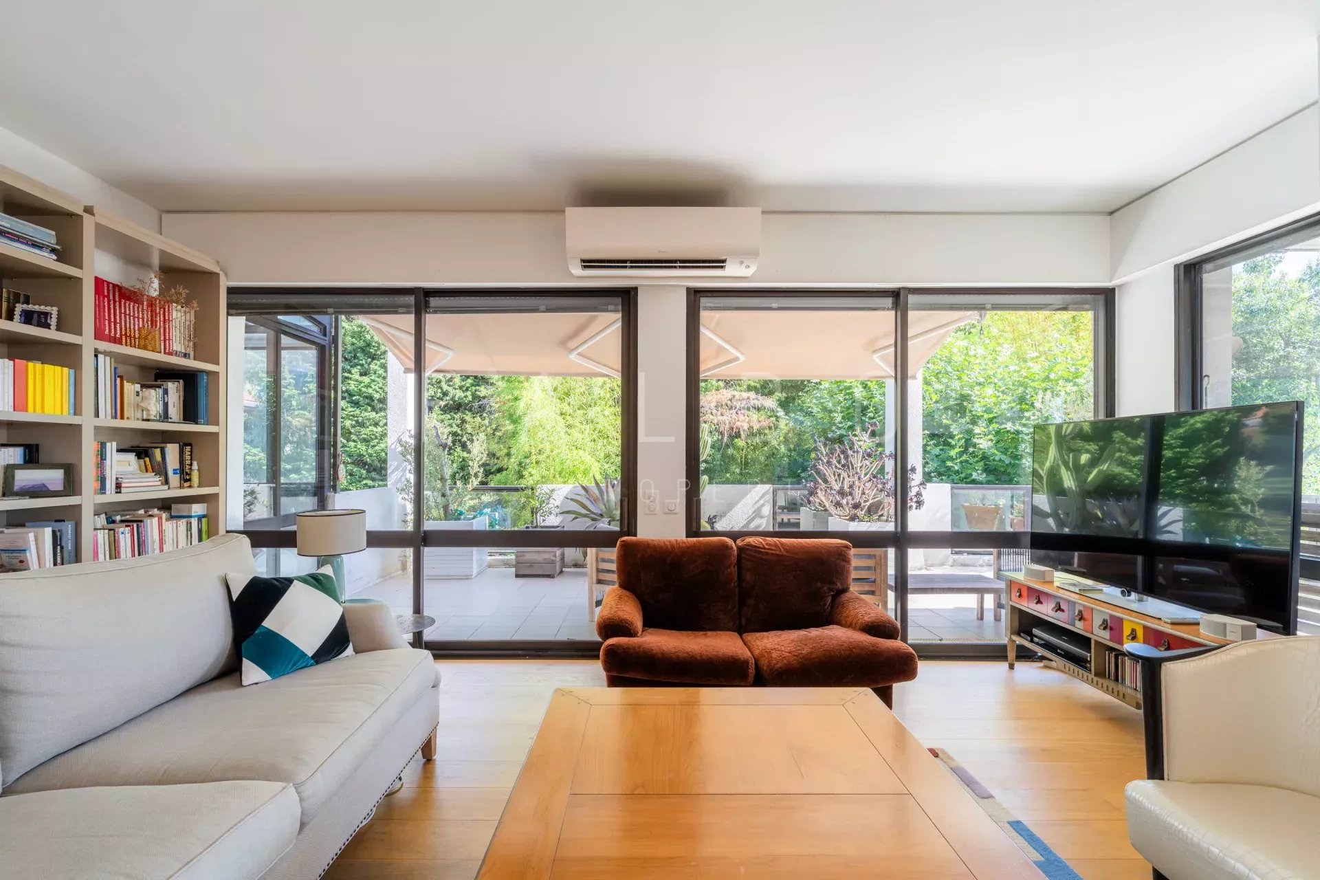 Intérieur d'un appartement moderne avec un salon lumineux et accès à une terrasse.