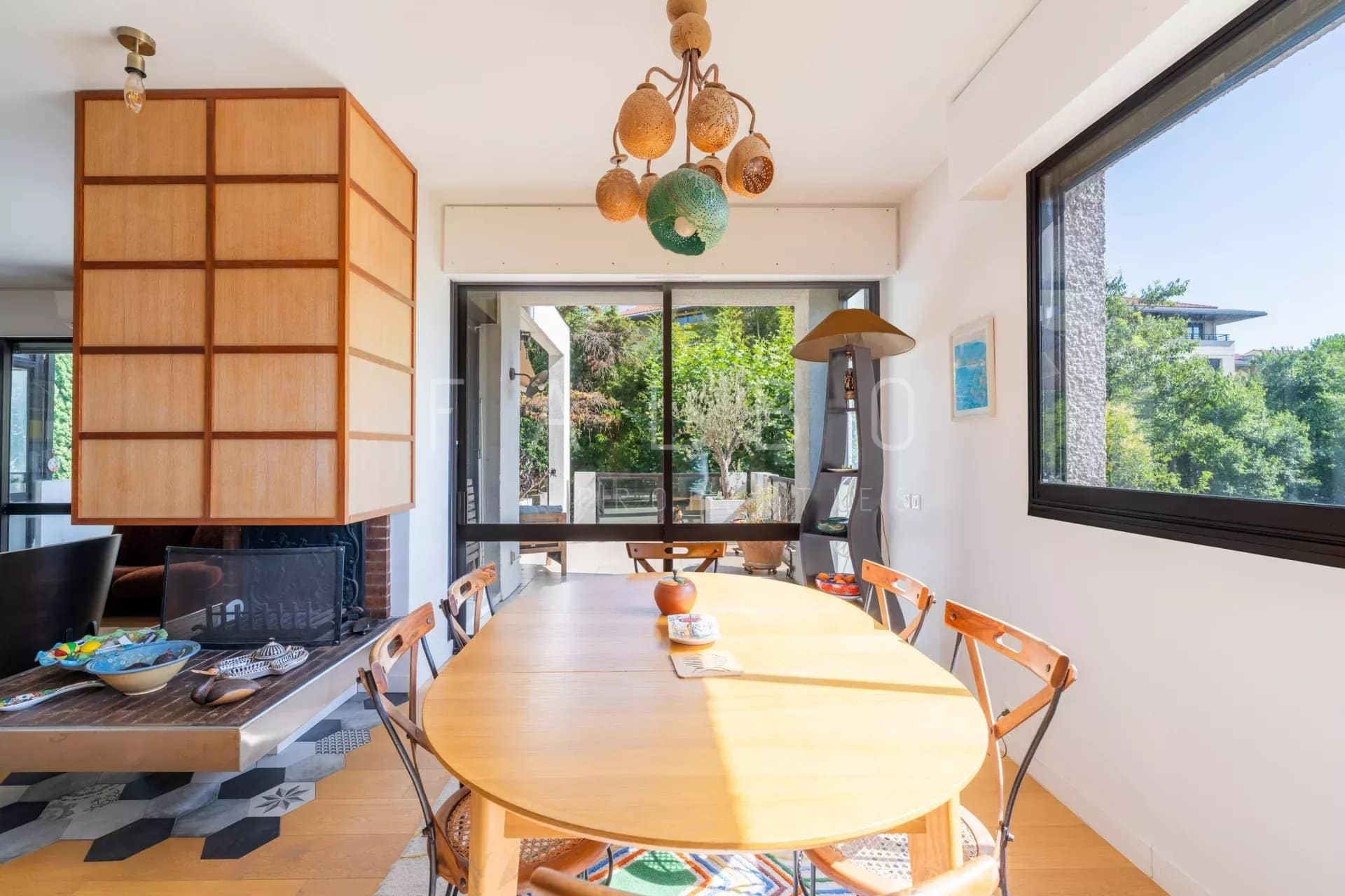 Salle à manger lumineuse d'un appartement moderne avec vue sur la verdure à Marseille 8e.