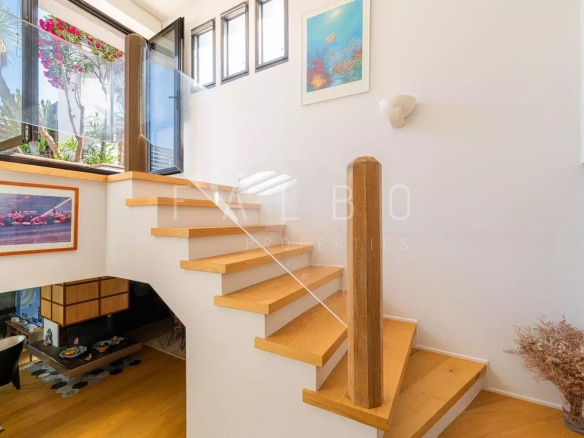 Escalier en bois menant à un étage supérieur dans un appartement moderne.