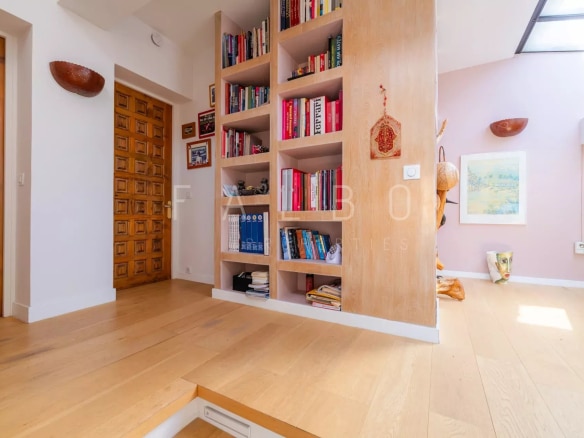 Intérieur d'un appartement moderne avec bibliothèque intégrée et espace de vie lumineux à Marseille 8e.
