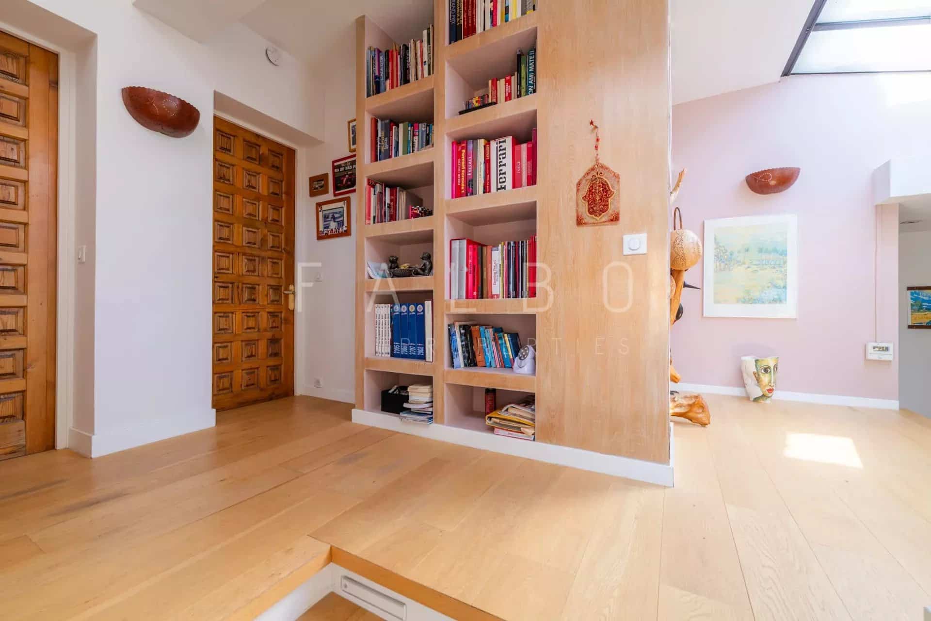 Intérieur d'un appartement moderne avec bibliothèque intégrée et espace de vie lumineux à Marseille 8e.