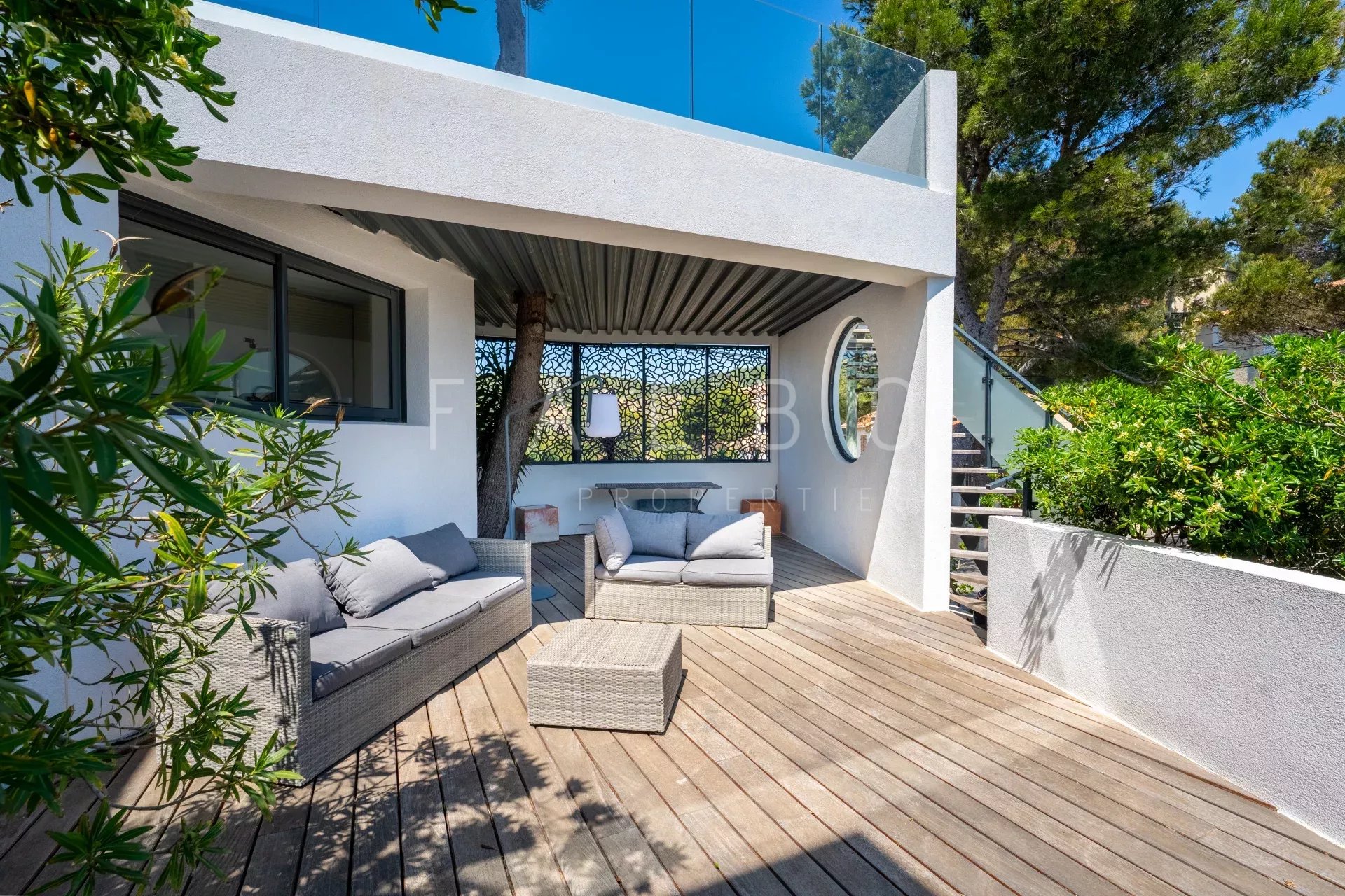 Terrasse d'une villa contemporaine avec mobilier extérieur, située en front de mer à Ensuès-la-Redonne.
