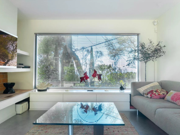 Intérieur d'une villa contemporaine avec vue sur la mer, salon lumineux et moderne.