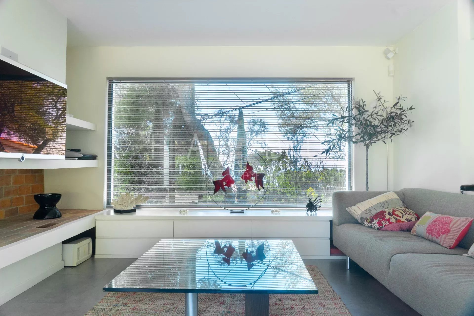 Intérieur d'une villa contemporaine avec vue sur la mer, salon lumineux et moderne.