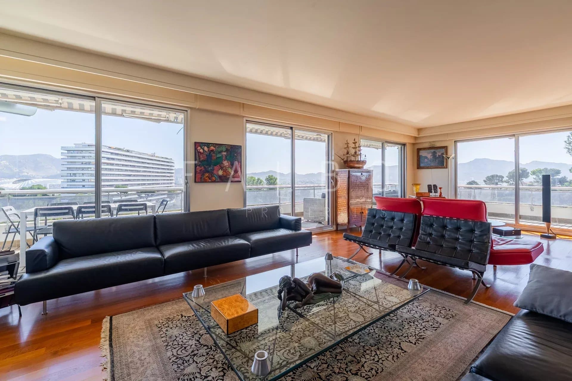 Salon d'un appartement avec vue mer, grande terrasse et mobilier moderne à Marseille 8e.