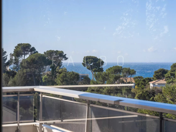 Vue mer depuis une terrasse d'appartement à Marseille 8e, entourée de pins.