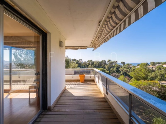 Terrasse d'un appartement avec vue sur la mer à Marseille, entourée de pins.